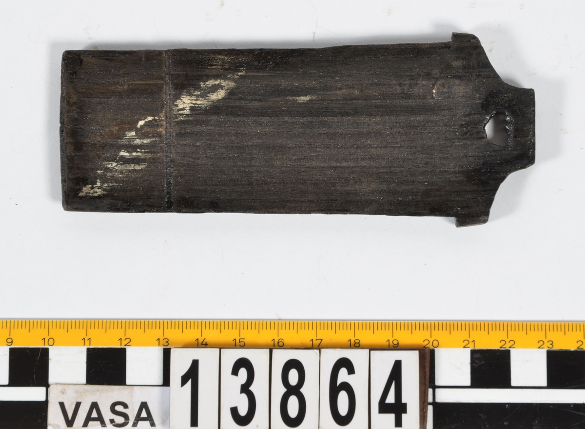 Ett litet träskrin med skjutlock.
Skrinets gavlar och långsidor är sinkade. Bottnen sitter infälld i gavlarna och är fästad med trästift vid långsidorna. Skrinet är försett med tre, löstagbara mellanväggar. På insidan av skrinet finns spår för mellanväggarna och för locket. Lockets ena ände är profilerad och har en liten halvcirkelformad urholkning som fungerar som tumgrepp. Den profilerade änden skjuter ut en bit utanför skrinet, då locket är stängt.
Två av skrinets mellanväggar samt en av långsidorna är rekonstruerade. Längs med skrinets ena långsidan löper en spricka. Skrinet är i gott skick.