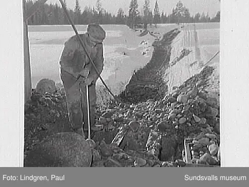 Rännö by, Matfors. Män arbetar med sten, pojkar spelar kula, fabrikbyggnad, hus exteriör.