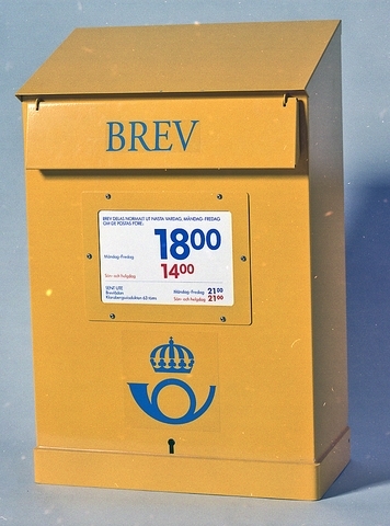 Gul brevlåda av vanlig modell med blå text på klaffen. En postsymbol i blått under anslagsfönstret. Anslag om tömningstider sitter i anslagsfönstret. Nyckel tillhör.