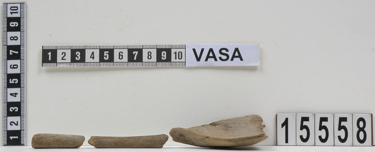 En träsked, bruten i fyra delar.

Skedskaftet är rakt och avsmalnande mot skedbladet. Skaftändens baksida är något avfasad. Skedbladet har ursprungligen troligtvis varit ovalt.

Skeden är mycket ömtålig. Skaftet är brutet på två ställen. Skedbladets övre parti saknas.

För mer information se Dokumentationsblankett under Referenser – Länkade filer.