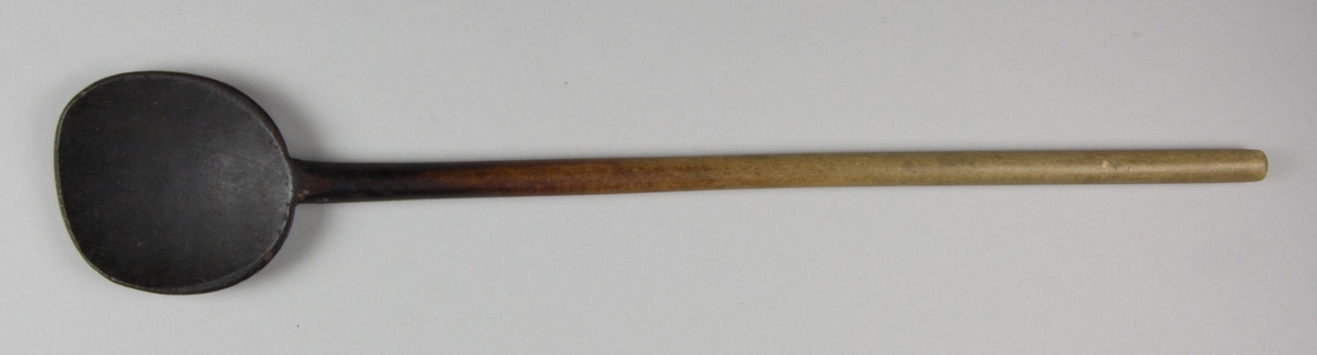 Slev skuren av trä. Med smalt rakt skaft. Grunt runt blad.