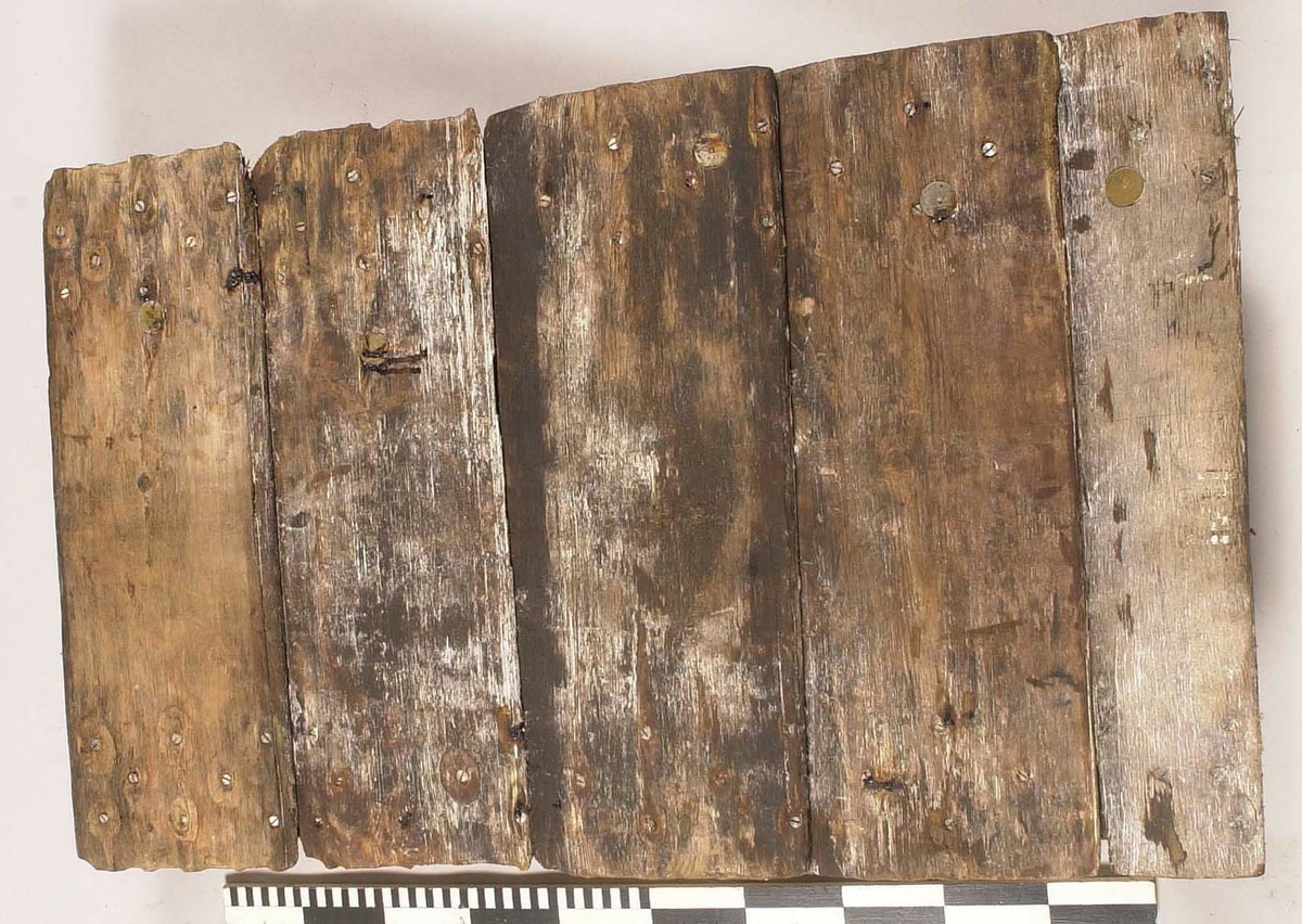 Tvärslå till däckslucka.
Fasad i båda ändarna. Tre genomgående hål i ena änden, ett i det andra.
Fäst vid fem brädor med ca 30 skruvar.