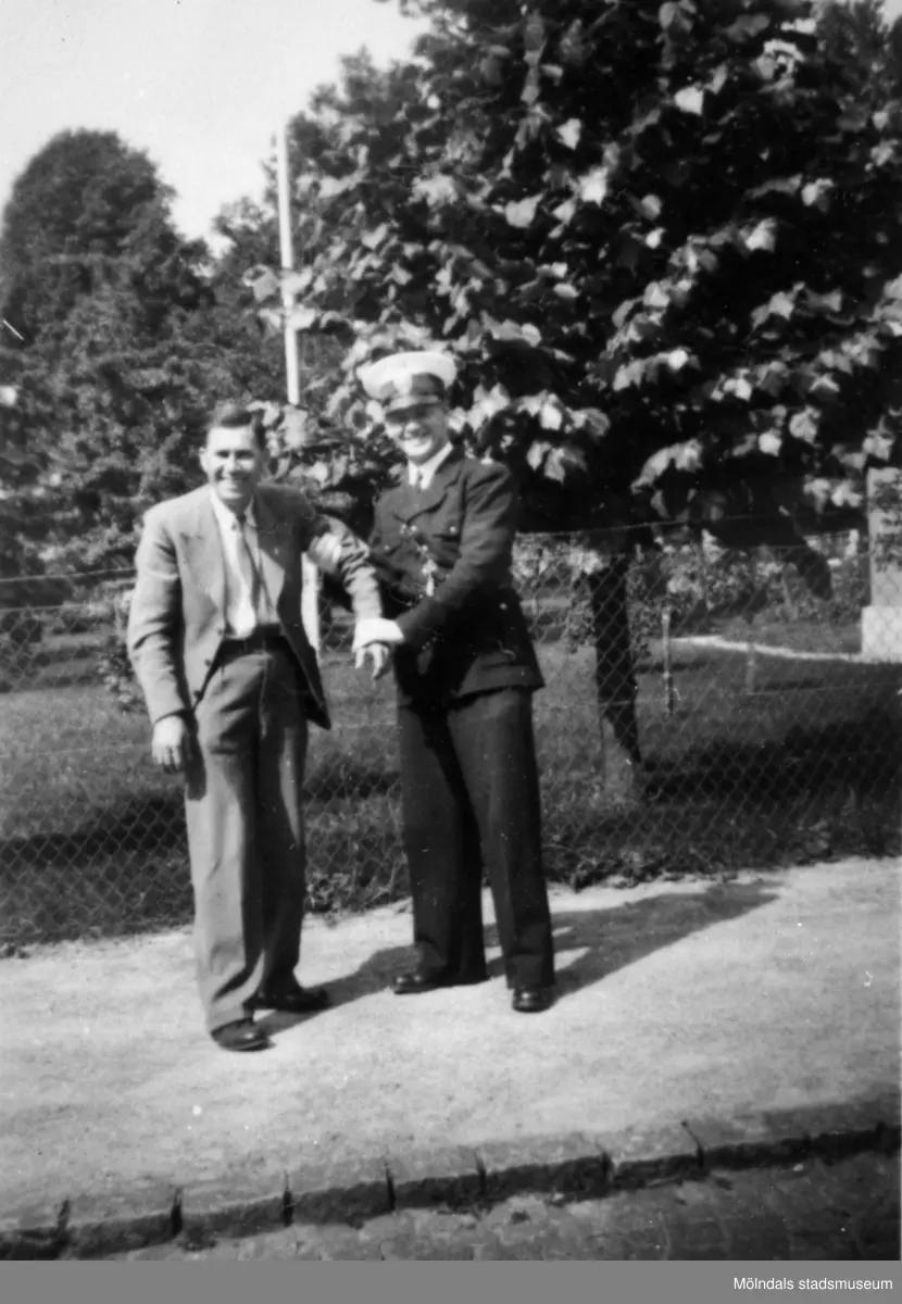 "Karantänsförläggning" på Kvarnbyskolan för överlevande från koncentrationsläger i Tyskland och Polen 1945.  
Skolan fungerade under denna sommar som beredsskapssjukhus.
 
Två män fotograferade utomhus, en av dem är Röda korset-personal.