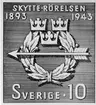 Skytte - rörelsen 1943. Godkänd originalteckning av Torsten Schonberg. Foto 1940-talet. Emission till 50-årsminnet av frivilliga skytterörelsens tillkomst. 
Utgivet 22/7 1943. Teckningen av Torsten Schonberg. Emblemet utgör skytterörelsens medlemsmärke. Valör 10 öre.