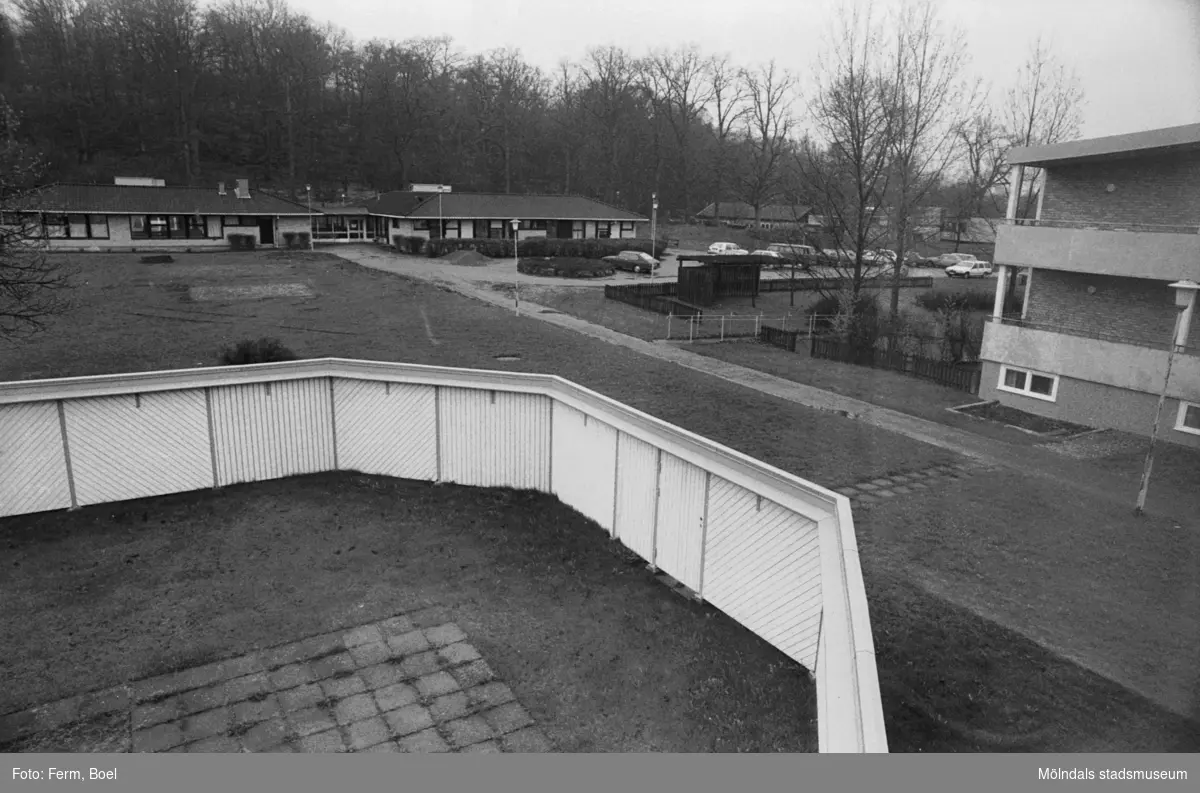 Dokumentation av Sagåsens flyktingförläggning 1992. Utsikt från en inhägnad utomhus-lekplats mot fastigheter i bakgrunden.