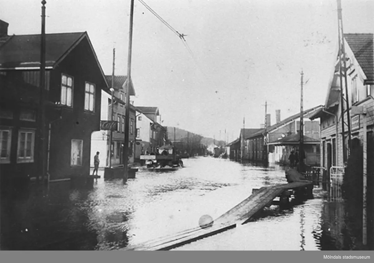 Översvämning i Mölndal, 1930-tal. Från vänster ses Kungsbackavägen 2 samt Göteborgsvägen 1 och 3. 
På andra sidan vägen ses spårvagnsstallarna (hörnet mellan Göteborgsvägen och Kvarnbygatan) samt bankhuset på Kungsbackavägen 1. 
(Hantverkshuset är ännu inte byggt, det uppfördes 1932.)