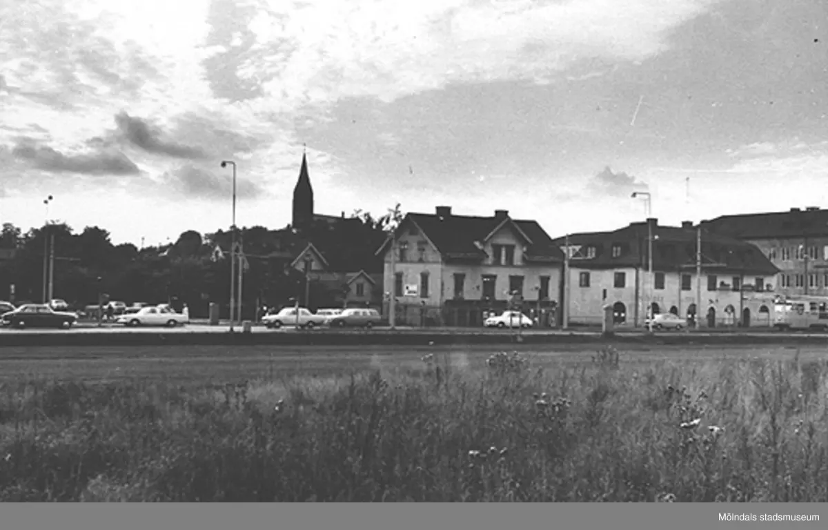 Vy mot affärsbyggnader längs Kungsbackavägen där Fässbergskyrkan syns i bakgrunden, 1970-tal. Man ser Kungsbackavägen 6: Karlssons Järn. Kungsbackavägen 4: Affärsbyggnad, Bergs frisersalong, Skånska bageriet och Landerös radio. Kungsbackavägen 2/Frölundagatan 1: Hantverkshuset med Götabanken,
Posten och Restaurang Gillet.