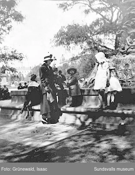 Sigrid Hjertén, sonen Iván Grünewald och kusiner vid Molins fontän i Kungsträdgården, juni 1915.