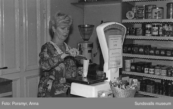 Kaffeaffären IDO, Nybrogatan. Bildsvit gjord för dokumentation utförd 1996. Affärsrörelsen grundades av Carl Dahlström den 18 november 1931. Dahlström föddes i Närsta, Alnö. Han arbetade som kassör på Hörningsholms sågverk 1918 till 1930 då sågen lades ner. Han fick inspirartion att starta kaffehandeln av sin bror Erland som arbetade på Kolonialvaruaktiebolaget. Mellan 1931 till 1937 drev Dahlström kaffehandeln tills en anställd, Eva Farm, tog över som nästa ägare. Sune Bäckström som tidigare arbetat som springpojke på firman tog över verksamheten 1954. Rosteriet som tidigare låg i magasinskvarteren (nuvarande Kulturmagasinet) flyttades 1983 till innergården vid Blombergska huset och en specialbyggd skorsten fick uppföras. Tonvikten på försäljningen ligger numera (2020) på ett välsorterat utbud av olika tesorter.