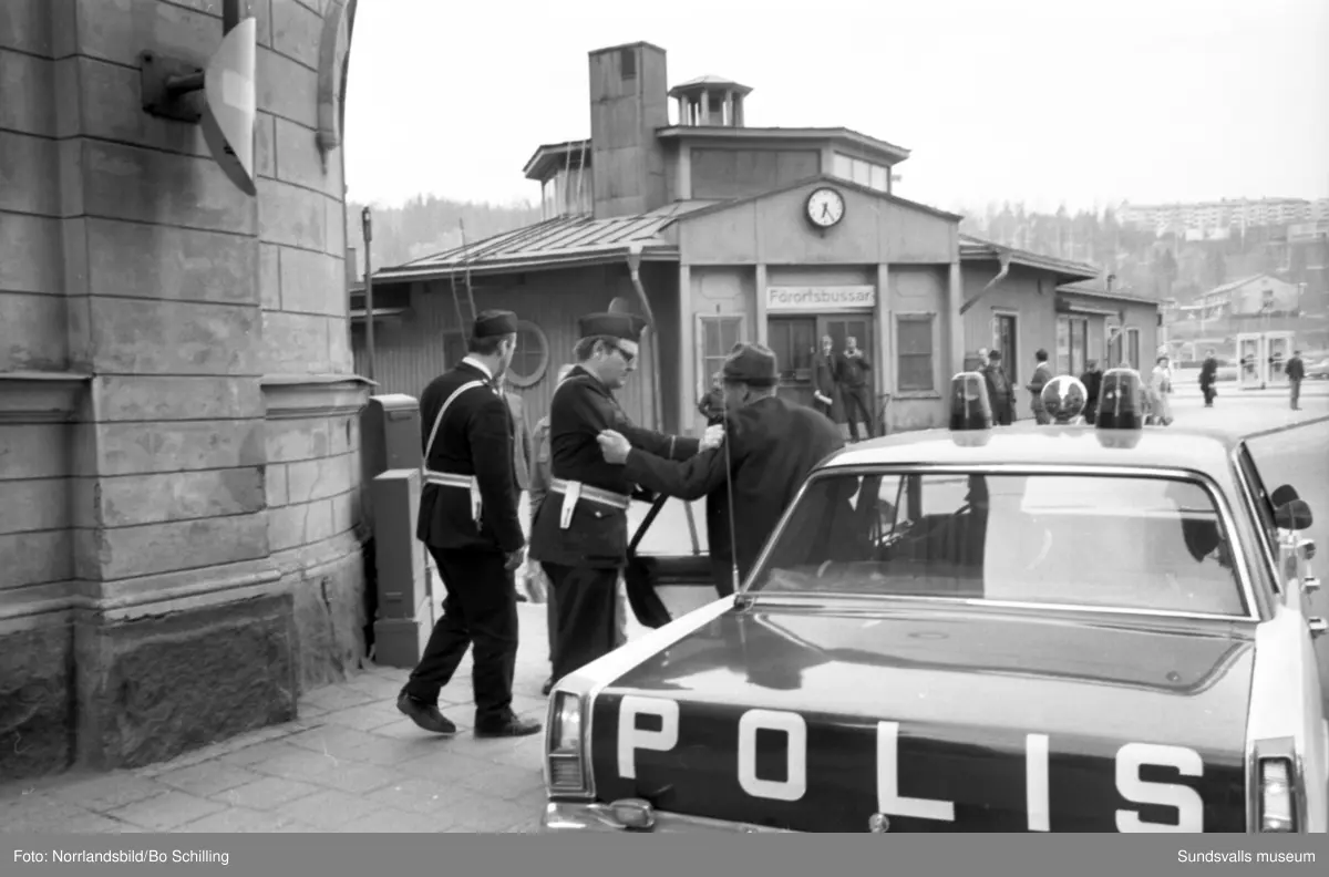 Gamla busstationen både exteriörer och interiörer med väntande resenärer i vänthallen, kiosk, personal i biljettkassan och bussgodsterminalen. Även ett polisingripande utanför finns dokumenterat. Bilderna hör till ett reportage i fackföreningstidningen Transportarbetaren.