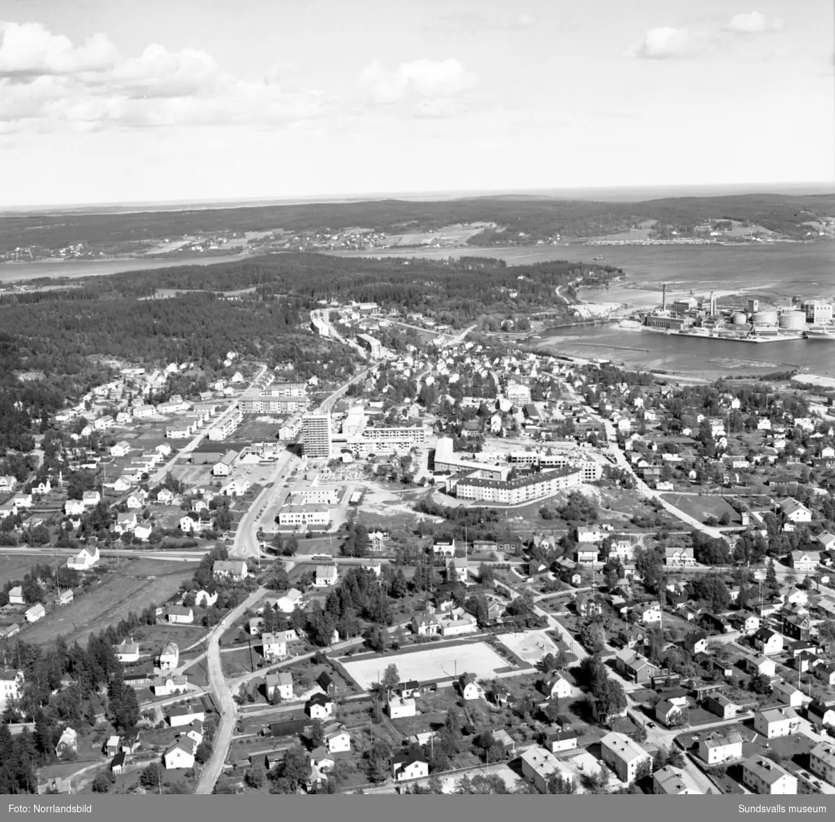 Flygfoto över Skönsberg ut mot Ortviken. Byggnation av hus i centrum, bland annat höghuset.