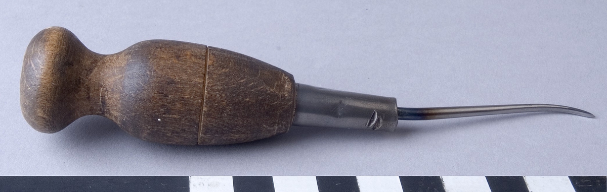 Syl, flatsyl, fabriksgjord, av stål med svarvat handtag av trä. Sylen är fäst i handtaget med hjälp av en metallhylsa och är böjd framtill med slipat platt skär.
Märkt:"LEO LAMMERTZ" och "270".