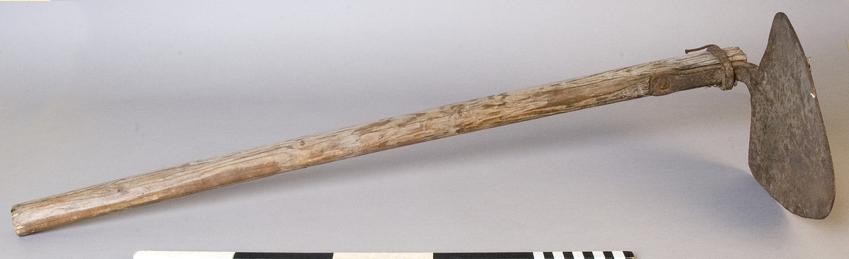 Hacka, med handtag av trä och blad av järn. Sedvanlig modell med trekantigt blad.