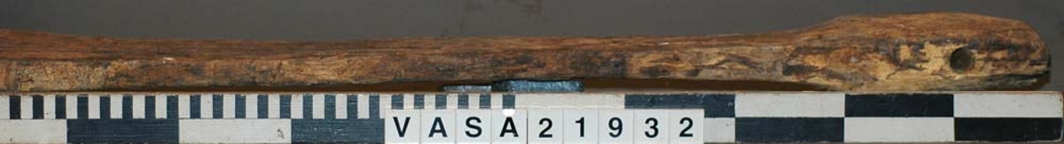 Ett roder till mindre båt.
Rodret har ursprungligen varit sammansatt av två delar varav den mindre, aktre biten saknas.  På den förliga delen finns tydliga spår av beslag. Högst upp på rodret finns ett hål för rorkult.