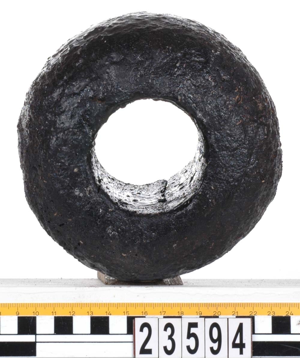 Rackklot. Runt svarvat klot med ett borrat genomgående hål. Eroderat. Tydliga sprickbildningar.