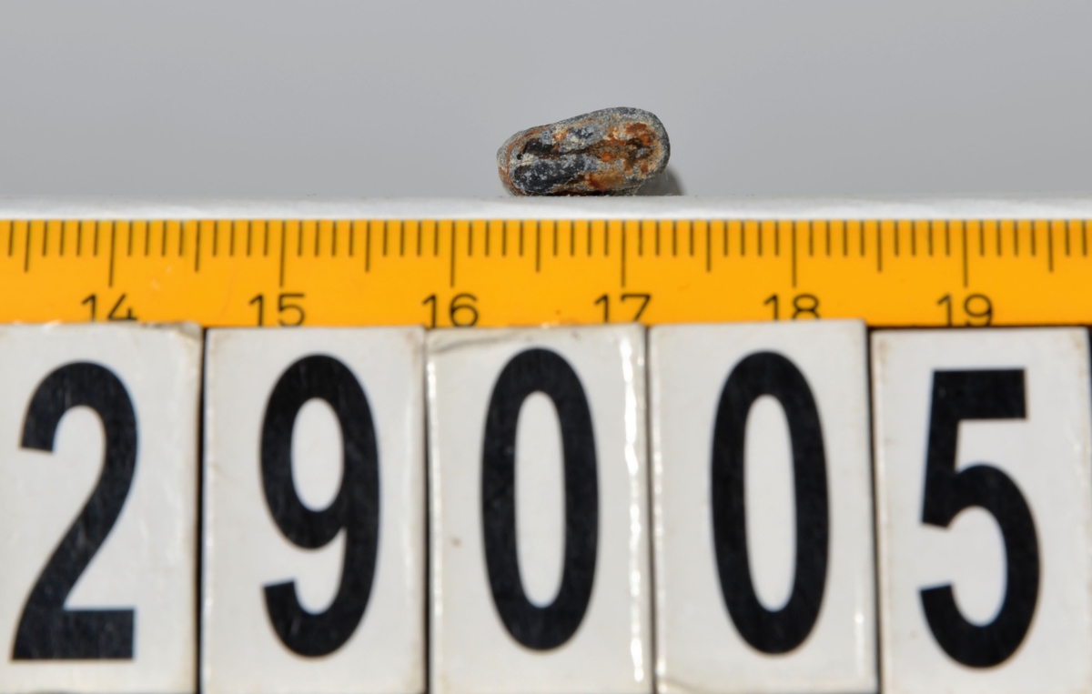 Sänket består av en vikt blybit. Sänket har tydliga märken efter det verktyg som pressat ihop sänket runt garntråden. Sänket är i gott skick.

Text in English: Lead sinker in the shape of a flat tube. The rectangular piece of lead is folded vertically in half and has visible tool marks from the folding process. The yarn is pushed through the hole. Grey mat in colour. In good condition.