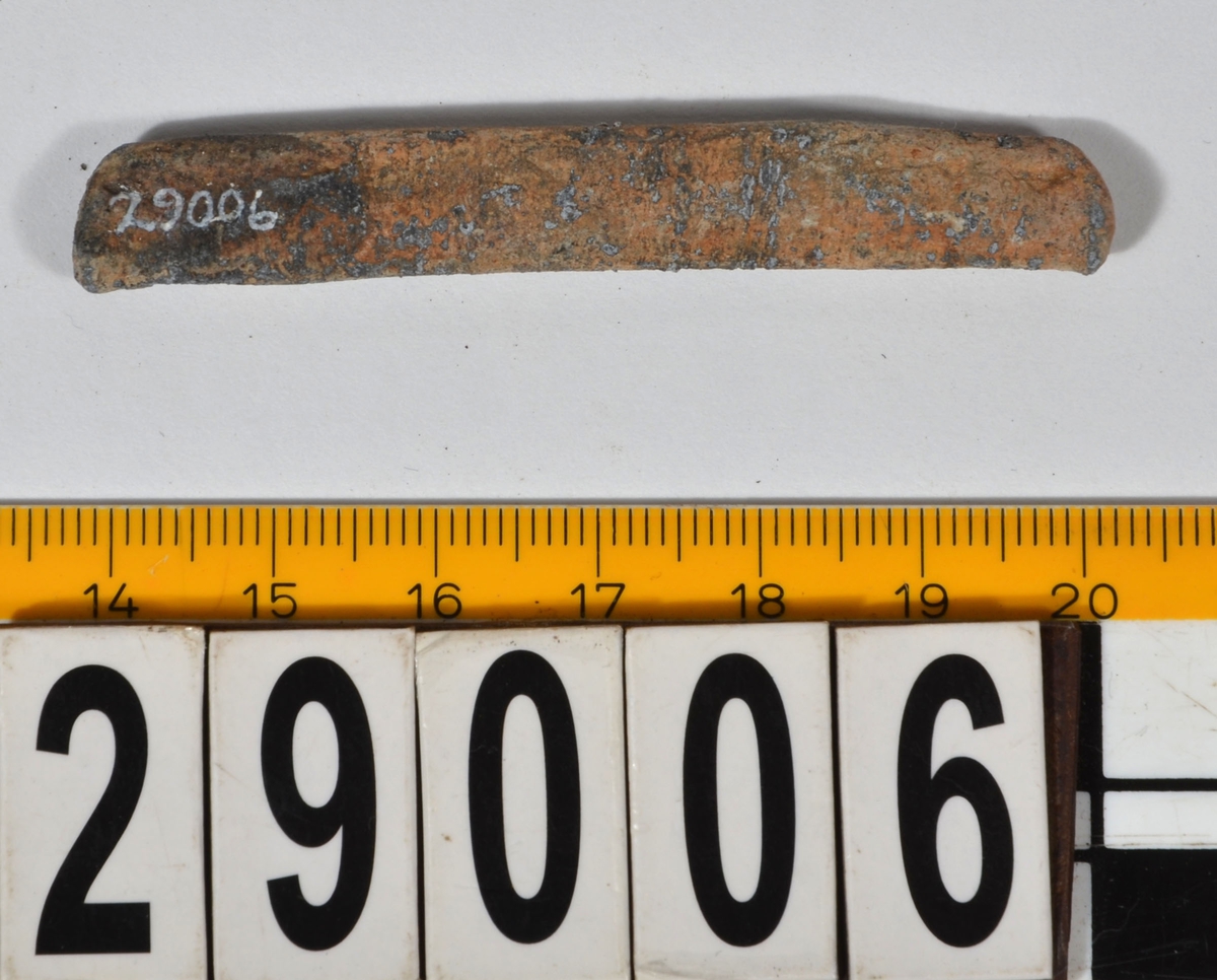 Sänket består av vikt blybit. Sänket har tydliga märken efter det verktyg som pressat ihop sänket runt garntråden. Sänket är i gott skick.

Text in English: Lead sinker in the shape of a flat tube. The rectangular piece of lead is folded vertically in half and has visible tool marks from the folding process. The yarn is pushed through the hole. Grey mat in colour. In good condition.