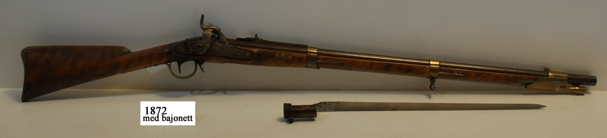 Gevär, 1815 - 1845 - 1848 års reparationsmodell, s.k. tappgevär, slaglås (Tischgevär). Märkt: Tre kronor. Kolven av trä, pipa och mekanism av stål. Beslagen av metall. Pipan räfflad.
