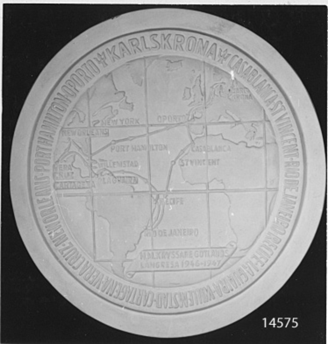 Minnespenning. På baksidan: Karta i relief över resrouten med namn på de hamnar som besökts, samt text: H.M. Gotlands långresa 1946-1947. runt om: Karlskrona, Casablanca, St. Vincent, Rio de Janeiro, Recifw, Laguaira, Willemstad, Cartagona, Vera Cruz, New Orleans, Port Hamilton, Oporto.