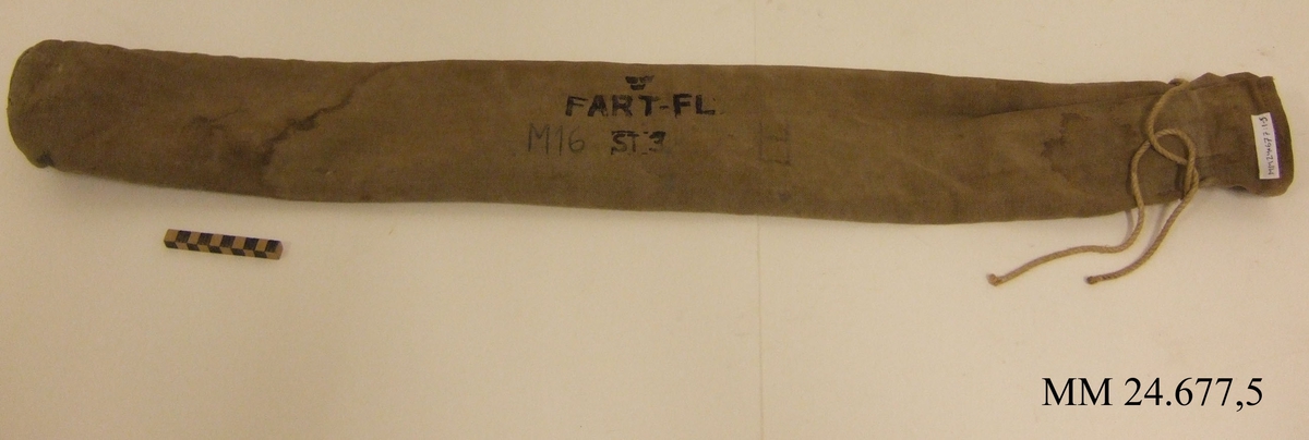Påse av kraftig, beige kanvas. cylinderformad med öppning som stängs med snöre. Påsen märkt: "tre kronor", "FART-FL ST 3" "M16".