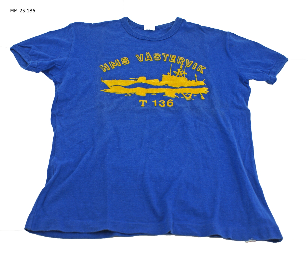 Marinblå kortärmad t-shirt med gult tryck i plyschaktigt material. Text: "HMS Västervik T 136" och en torpedbåt till sjöss.