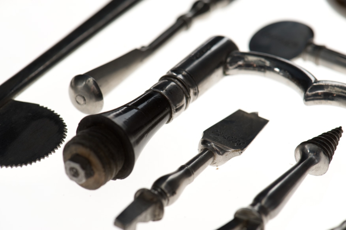 Helt fodrad invändigt med röd sammet och med löst innerfack av mahogny. Till kistan hör ett löst läderfodral märkt N:o 1.
Kistan är tillverkad av C.F. Ponsbach, kirurgisk instumentmakare vid Kungl. Karolinska Institutet, Kungsholmen, Stockholm, åren 1830-35. Samtliga instument är signerade "Ponsbach" och i locket på kistan finnes en tryckt etikett av äggrund form med texten : "TILLWÄRKAS af C.F. PONSBACH Chirurgisk Instumentmakare i Stockholm, Kongl. Carolin. Istitut. på Kongsholmen."

Kistan är försedd med lås och nyckel. Den har tillhört sjukvårdsutredning ombord för kanonjoll och varit förvarad å Sjukhusförrådet, Örlogsvarvet i Stockholm (1938).

Samtliga instrument är väl utförda och omfattar:
1/ Amputationskniv, 190 mm lång, med oval spets och
refflat svart träskaft.
2/ Amputationskniv, 160 mm lång, med oval spets och
refflat svart träskaft.
3/ Kniv med lancettspets, 130 mm lång med refflat svart
träskaft.
4/ Kniv med lancettspets, 93 mm lång med refflat svart
träskaft.
5/ Avbitaretång, helt i stål, 164 mm lång.
6/ Kulutrdragaretång, helt stål, 205 mm, med skaftet refflat.
7/ Tandtång, helt stål, med skaftet refflat, 130 mm lång.
8/ Tandtång, helt stål, med skaftet refflat, 135 mm lång.
9/ Tandnyckel, 150 mm inklusive polerat mahognyskaft.
10/ Lös krok till ovanstående tandnyckel, 25 mm, helt stål.
11/ Lös krok d:o    d:o    d:o    d:o    d:o
12/ Bensåg av fogsvanstyp, längd 260 mm, med mahognyskaft.
13/ Benskruv med ringformat handtag, 120 mm lång, helt stål.
14/ Munspatel med två skedblad, helt stål, 190 mm lång.
15/ Pincett av stål med lås, 90 mm.
16/ Fingersåg, 10 cm, med svart refflat träskaft.
17/ Operationsnålar, böjda, 12 st, för sutur.
18/ Troikar med kanyl, 82 mm, med svart polerat träskaft.
19/ Troikar med kanyl, 74 mm, d:o    d:o     d:o
20/ Lancett dold i benskaft, 110 mm lång, böjd.
21/ Geissfuss (getfot), 90 mm lång m. polerat skaft (tandutdragn.)
22/ Sax, rak, osignerad, ny, 150 mm.
23/ Bindtyg av brunt läder med tre små lancetter i svart benskaft.
24/ Tournikett-läderbitar, 60 x 80 mm, ljust läder.
25/ Pelott, kudde av kork, klädd med sämkinn, 40 x 60 mm.
26/ Artärnål, 70 mm, med brunt polerat träskaft.
27/ Fodral av mahogny med 5  skalpeller, en pincett och en liten
stålkrok (dissektionsbestick).
28/ Etui, litet, av rött läder med 6 st små lancetter i sköld-
paddskaft. Lancetterna märkta med ?C.F.P.?
29/ Trepanborr, rund, sågtandad, helt stål med pistill i mitten.
30/ Trepanborr, refflad  d:o    d:o   d:o   d:o
31/ Trepanborrsväng med skaft av polerat svart trä.
32/ Knapp till ovanstånende av   d:o   d:o
33/ Pistillnyckel till trepanstiftet.
34/ Trepanborr (spetsborr), helt stål.
35/ Tirefond, skruv för att draga ut benstycket vid trepanering.
36/ Trepanborr (tappborr), helt stål.
37/ Culter lenticularis med svart polerat skaft.
38/ Brosåg, tvåeggad, 35 mm, med svart polerat skaft.
39/ Raspator vinkelform, med skaft av polert trä, för att
bortskrapa benhinnan - periostet - vid trepanering.
40/ Benfil, längd 140 mm, med svart polerat skaft.
41/ Pincett, dubbel, helt av stål, längd 170 mm.
42/ Skalpell, rak, med polerat träskaft.
43/ Trepanborste i liten hornhylsa.
44/ Operationstråd på rulle, rött silke.
45/          D:o        d:o  oblekt linnetråd.
46/ Vaxbit till ovanstånde tråd.
47/ Ters av svartbetsat trä med märling, längd 120 mm.
48/ Ters  d:o   d:o   d:o       d:o     d:o
49/ Ters   d:o    d:o    d:o   d.o
50/ Tournikett av mässing med spärrhake, utan band.
51/ Tournikett   d:o     d:o      d:o      d:o
52/ Bindtyg av brunt läder innehållande lancetter i benskaft,
rakkniv, snabelsax, peang.
53/ Matstrupsintrument, liten svamp på smalt skaft av val-
fiskben.
54/ Bougier, kaustika, i papperfodral.
55/ Katetrar och sonder av gummi.
