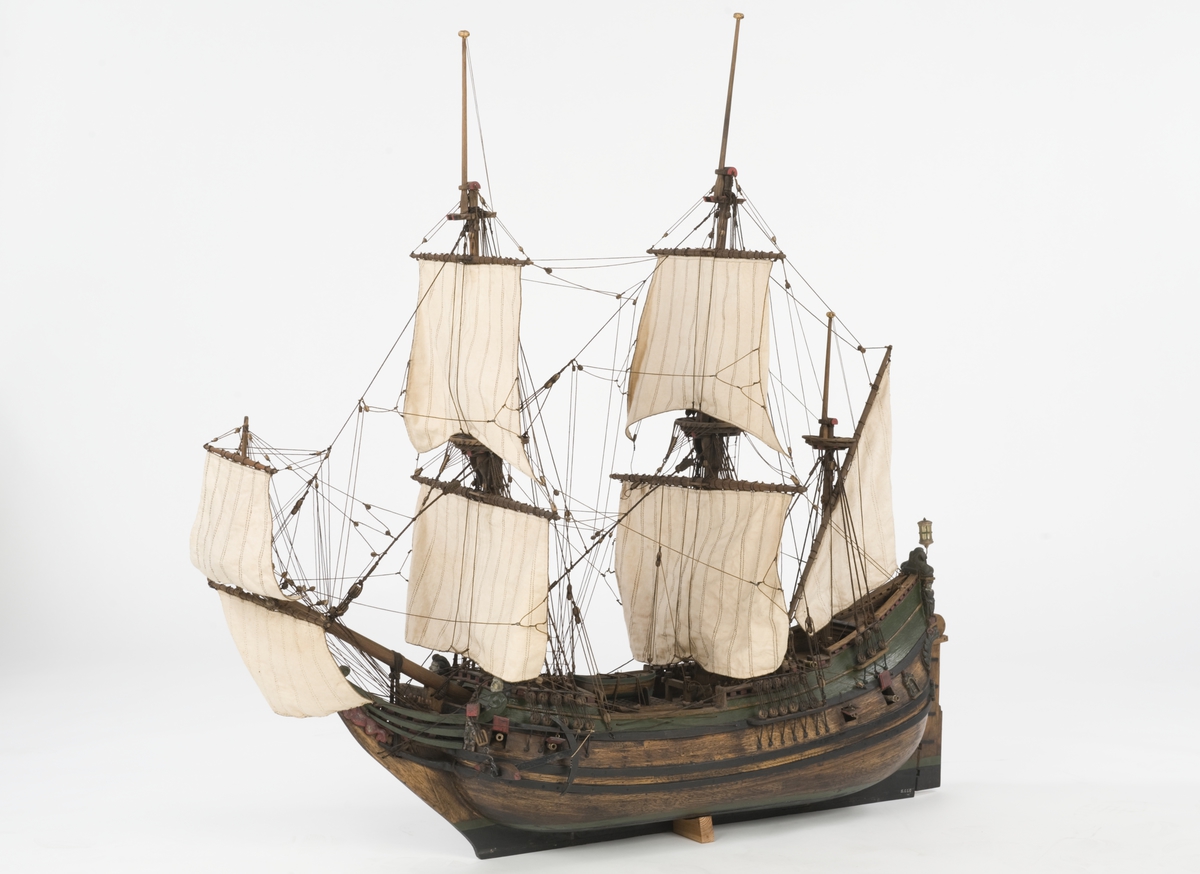 Flöjtskeppsmodell. Riggat med stående och löpande gods, segel av bomull. Bogspröt m. 2 blindor. Fock- o stormast med märs- och undersegel. Latinsegel på mesanmasten. Galjon m. lejon. 2 bogankare, båt på skrå midskeppsöver storluckan. På halvdäck 2 metallkanoner, 4 bogkanoner, samt 4 kanoner på låringen. 1 campagnelykta. Mörkbetsat skrov med 2 svarta berghult, svart bottenfärg. Akterspegel rikt ornerad med 6 fönster. Föremålets form: Helmodell