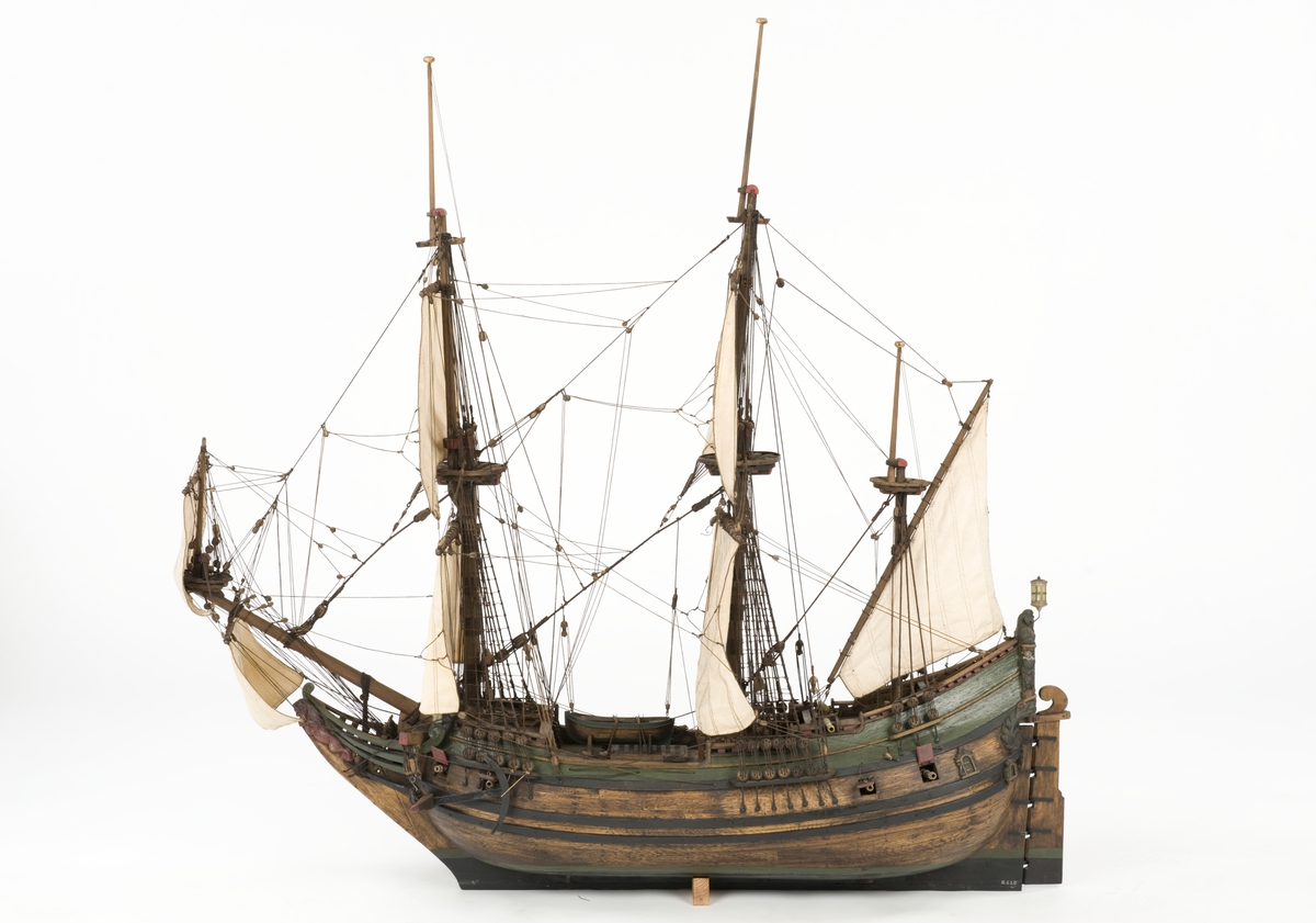 Flöjtskeppsmodell. Riggat med stående och löpande gods, segel av bomull. Bogspröt m. 2 blindor. Fock- o stormast med märs- och undersegel. Latinsegel på mesanmasten. Galjon m. lejon. 2 bogankare, båt på skrå midskeppsöver storluckan. På halvdäck 2 metallkanoner, 4 bogkanoner, samt 4 kanoner på låringen. 1 campagnelykta. Mörkbetsat skrov med 2 svarta berghult, svart bottenfärg. Akterspegel rikt ornerad med 6 fönster. Föremålets form: Helmodell