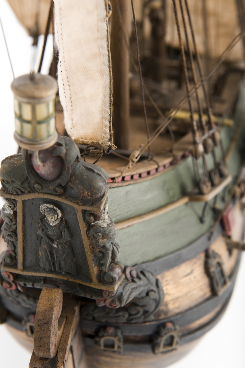 Flöjtskeppsmodell. Riggat med stående och löpande gods, segel av bomull. Bogspröt m. 2 blindor. Fock- o stormast med märs- och undersegel. Latinsegel på mesanmasten. Galjon m. lejon. 2 bogankare, båt på skrå midskeppsöver storluckan. På halvdäck 2 metallkanoner, 4 bogkanoner, samt 4 kanoner på låringen. 1 campagnelykta. Mörkbetsat skrov med 2 svarta berghult, svart bottenfärg. Akterspegel rikt ornerad med 6 fönster. Föremålets form: Helmodell