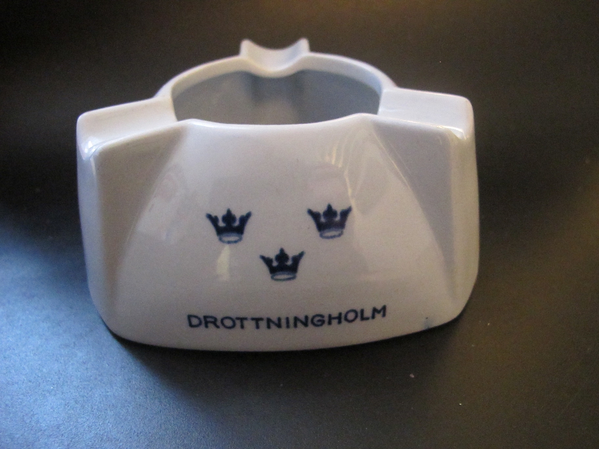 Trekantig i ljusblått porslin med höga, rundad kant avslutat med ett runt hål och tre "cigaretthållare". Text i mörkblått: KUNGSHOLM, GRIPSHOLM, DROTTNINGHOLM med SALs emblem tre kronom över vardera namnet.
Text under botten: SWEDISH AMERICAN LINE GOTHENBURG DIRECT NEW YORK & CANADAFöremålets form: Trekantig
