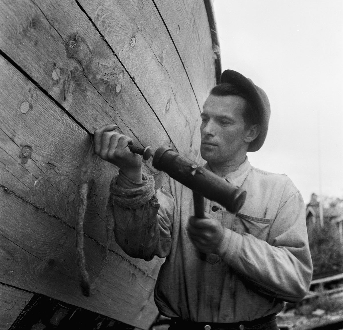 Motorgaleasen Ellen av Böda på slipen för reparation. Mannen på bilden är Peter Petersen. 
Småland, Kalmar län, Stranda härad, Döderhults socken, Saltvik.