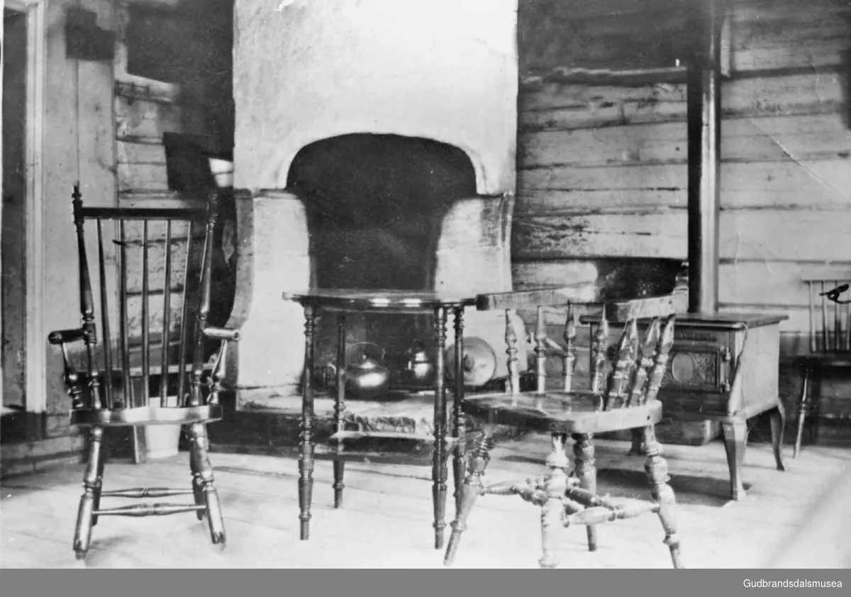 Interiør i hus på Kirkely, blant annet stoler, bord og hjørnepeis.