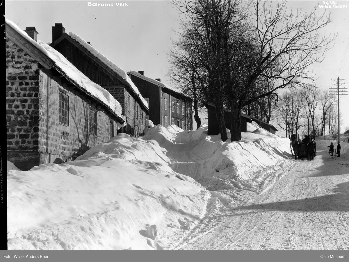 Bærums Verk, Verksgata, trehusbebyggelse, snø, vei, brøytekanter, hest, slede, sparkstøttinger, barn, telegrafstolpe