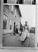 Elin Liljefors på cykel. I bakgrunden Albin, Minnie, Olle och Carin, Svartbäcksgatan 37, Uppsala 1900