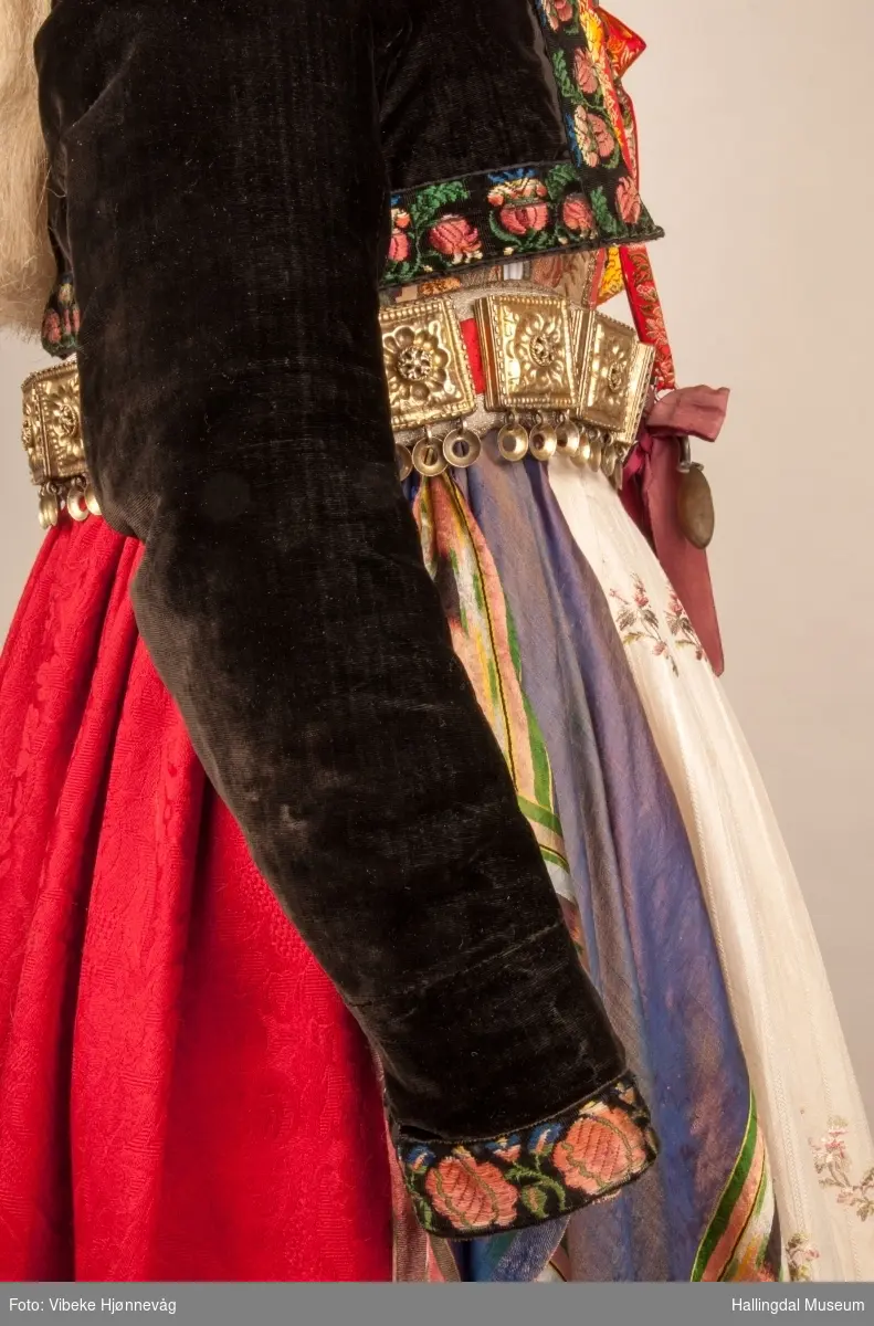 Drakten står utstilt i den faste bunadutstillingen på Hallingdal Museum, Nesbyen.  Den ble satt opp på grunnlag av et bilde fra Norsk Folkemuseum, tatt ang. av Axel Lindahl.  Tidfestet til 1877-78.  Høyde på overdel ble bestemt etter lengden på trøya.  Utelatelsen av det store bryststykket og andre forandringer ble diskutert med Ågot Noss og godkjent.  Ny dokke ble bygd opp med utgangspunkt i stakkens mål.
HFN 03387-stakk med liv.  Stakk og liv ble skilt 5.1.1999, rød ulltråd med tråklesting festet delene sammen, fjernet.  Stakk festet til liv i ny høyde med store attersting med rødt bomullsgarn.  Det ble sydd understakk i ubleket lerret med vattering av dacronvatt, for å få riktig profil.
HFN 03386 Forkle er noe for kort.
HFN ? Skjortering, sydd fast i skjorta.
HFN 00677 sølje, sydd fast i skjorta.
HFN 00533 sølje sydd fast i skjorta.
HFN ? Perleklut, sydd fast i skjorta.
HFN 00560 Angus Dei, påsatt ny silkesnor.
HFN 06695 Silketørkle, blått, festet i forklesnora
HFN 03499 Silketørkle festet i forklesnora
HFN 06694 Silketørkle, rødt rundt halsen
HFN 03603 Brudelue
HFN 03137 Stølebelte, påsatt bendelbånd, disse ligger over skuldrene for å holde beltet oppe.
HFN 03318 Linskjorte.  Vasket: desember 2000
HFN 01815 trøye i svart speilfløyel.
