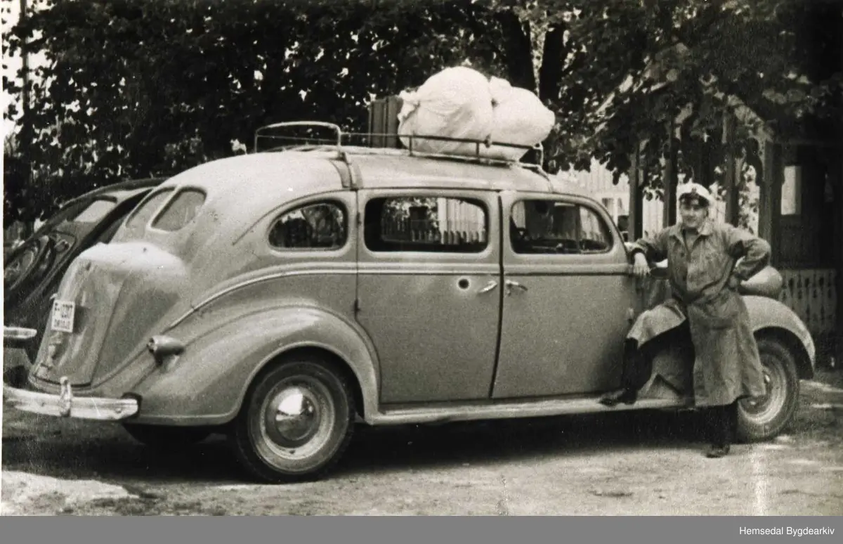 Knut E. Langehaug frå Hemsedal med drosje F12317, ein Chrysler 1937modell med 7-sete, ved Odnes Hotell 1948-1949. Bilen bak Opel Kaptain 1937 mod.