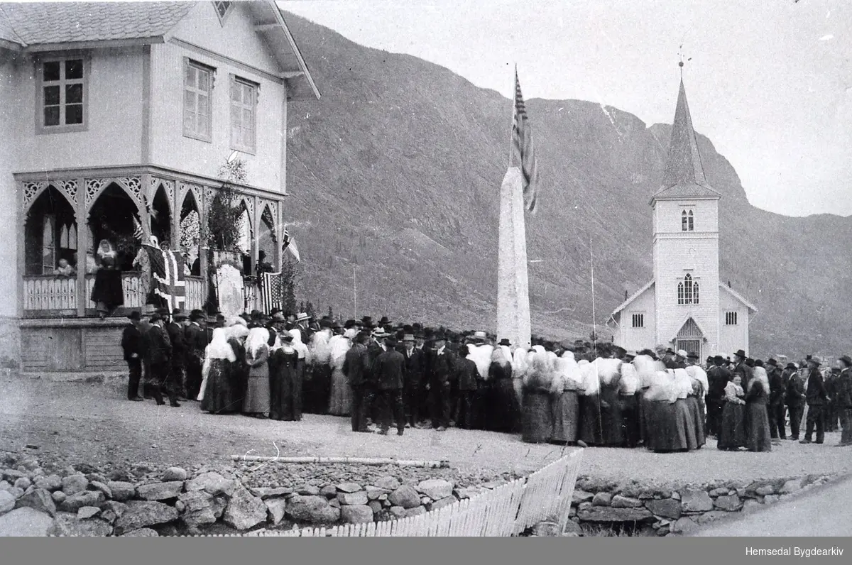 Ved Tingbygnaden (det gamle kommunehuset som låg der Kyrkjestugo/biblioteket ligg i dag - 2014)
Avduking av bautaen i 1914. Då Kyrkjestugo vart bygd på byrjnga av 1980-talet, vart bauten flytta til kyrkjegarden framfor kyrkja.