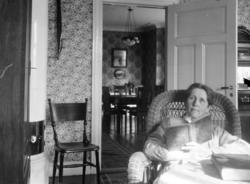 Porträtt av David Helldéns mamma Maria Helldén.
Med en bok i