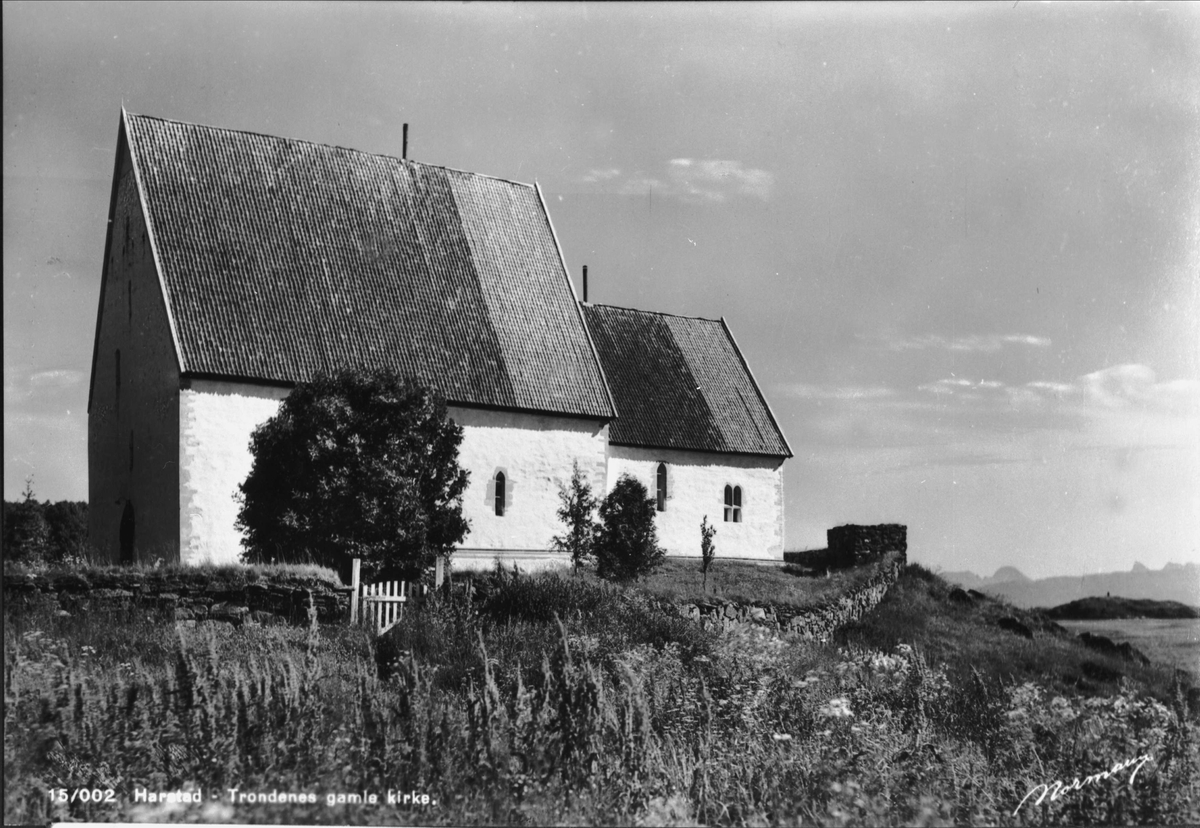 Trondenes kirke, fotografert mot nord med den gamle forsvarsmuren i forgrunnen.