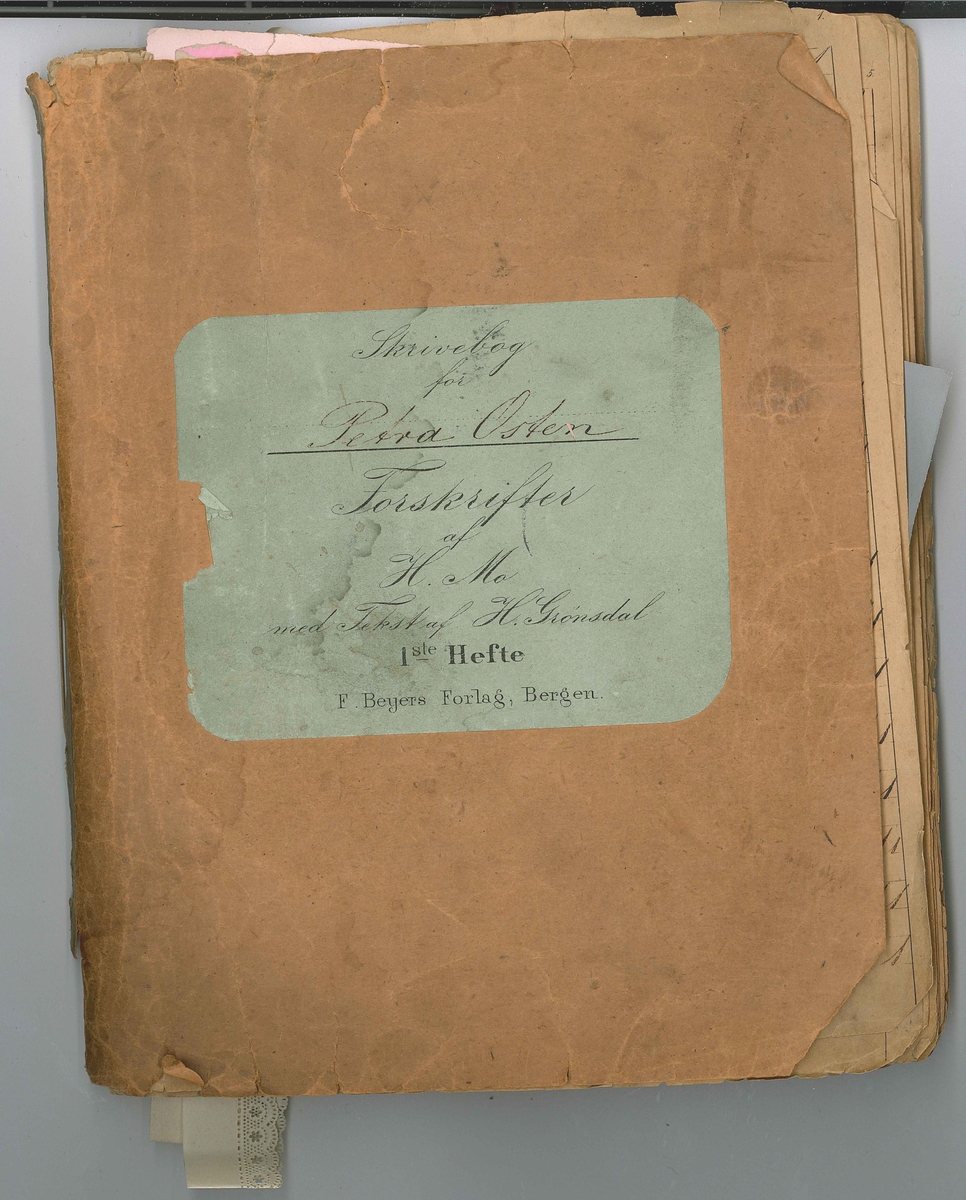 Ei skrivebok der ein har lagt sorterte haugar med dekorert papir, stoff, papirblonder o.a. i ulike fargar og mønster mellom sidene. Det er også silkepapir og heilt tynne ark i sølv og gull. Haugane er sorterte etter fargar og mønster. Skriveboka er utskriven med handskrift.