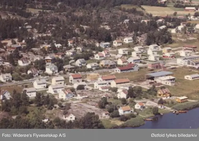 Oversiktsbilde over boliger og forretningsbygg ved Storveien, Ørebekk i Onsøy. Seutelven i forgrunnen.