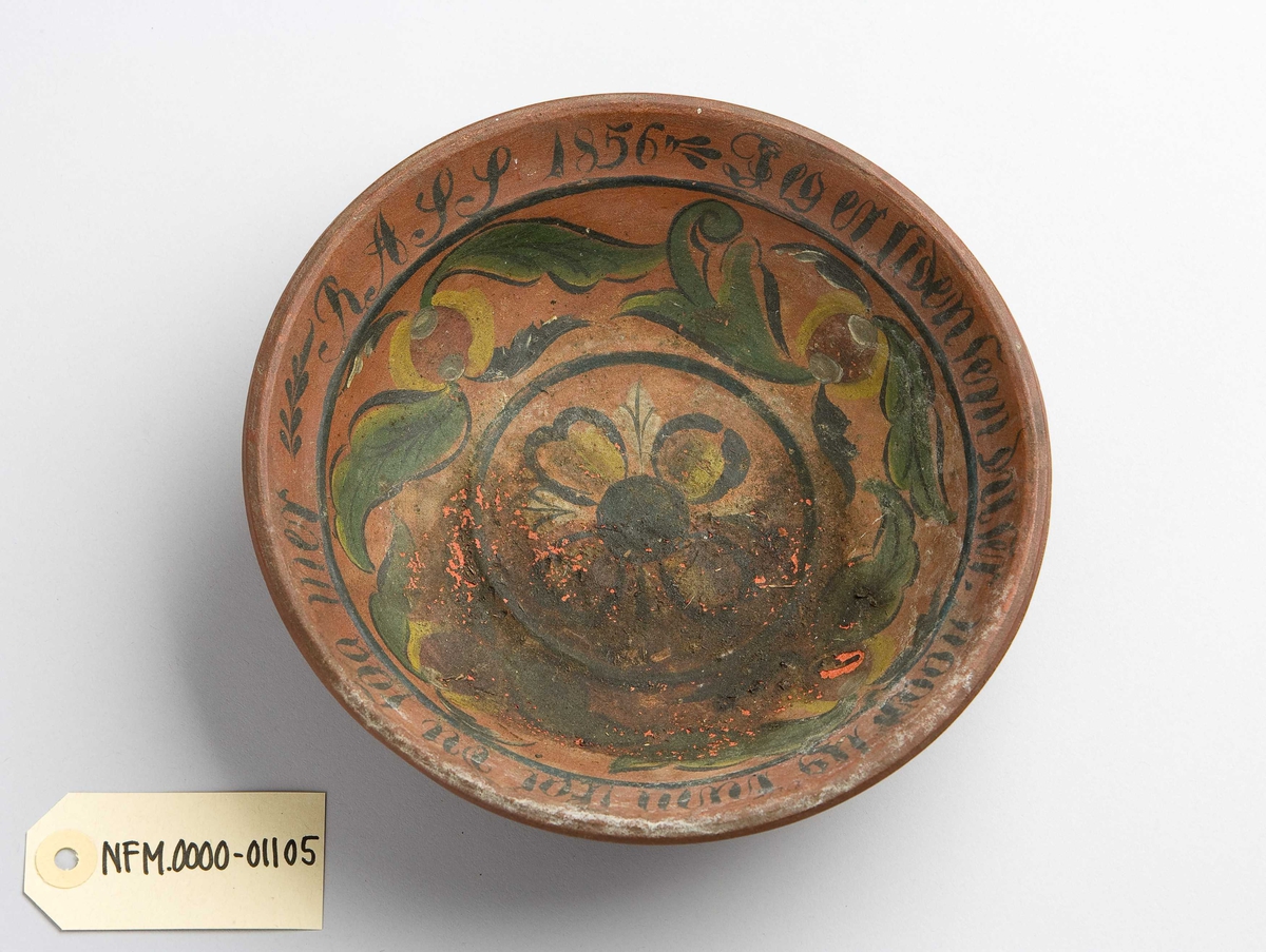 Liten rund ølbolle. Har handmåla dekor på innsida, blomsterliknande mønster.
