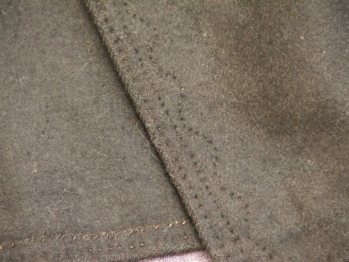 Svart blomstra silkeaktig band på
kragen. Rette og bølgeforma prydsaum på kvar side av opningen framme.