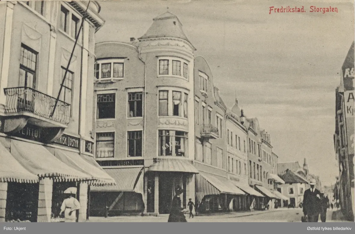 Gateparti fra Storgaten - 1910.
Samtlige hus på begge sider av Storgata  brant i 1908, det fins bilder fra 1910-1911 hvor byggene på hver side har  stillaser.

Gunnar Andreassen: 
Samtlige av disse husene hadde innvielsesår i 1909 iflg. "Arkitekturen i Fredrikstad" av Lars Ole Klavestad.