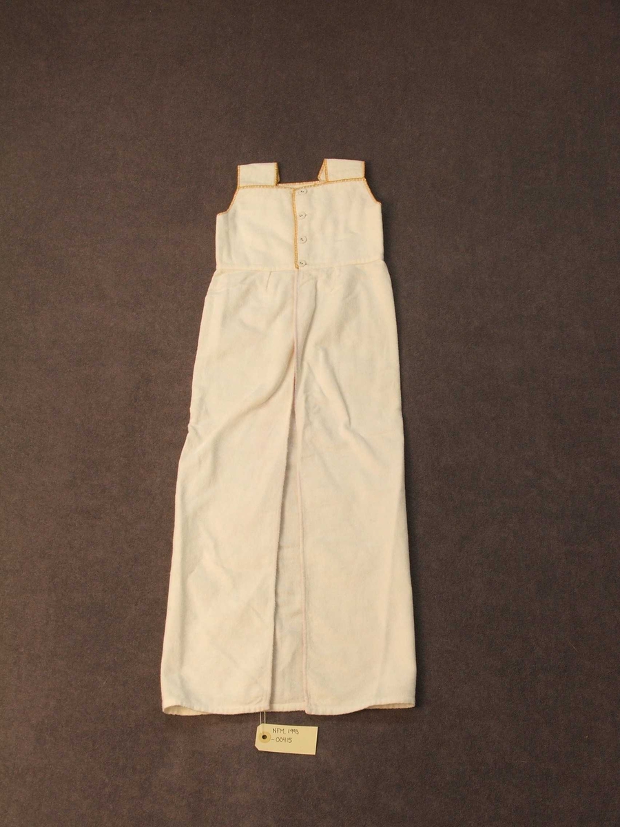 Den øvre delen er kanta med gule sting. Lerretsknappar; ein på kvart berestykke og for loddrett lukking 4 i øvre delen. Nedanfor knappane eitt stoffstykke som i kvar av dei to loddrette, innbretta sidene har 2 raude og ei blå stripe.