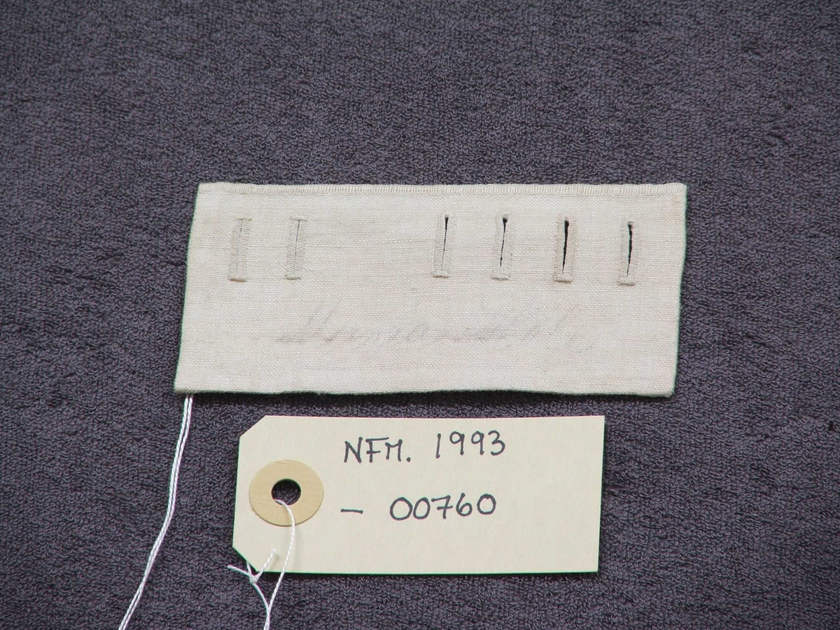 Saumprøve med seks knapphol sydd på.