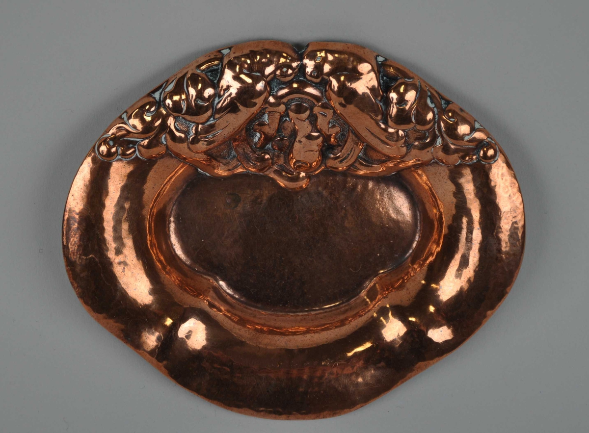 Motivet på askebegeret er to papegøyar som sit mot einannan med plantar/bladverk omkring seg. Desse hevar seg ut frå sjølve godset.