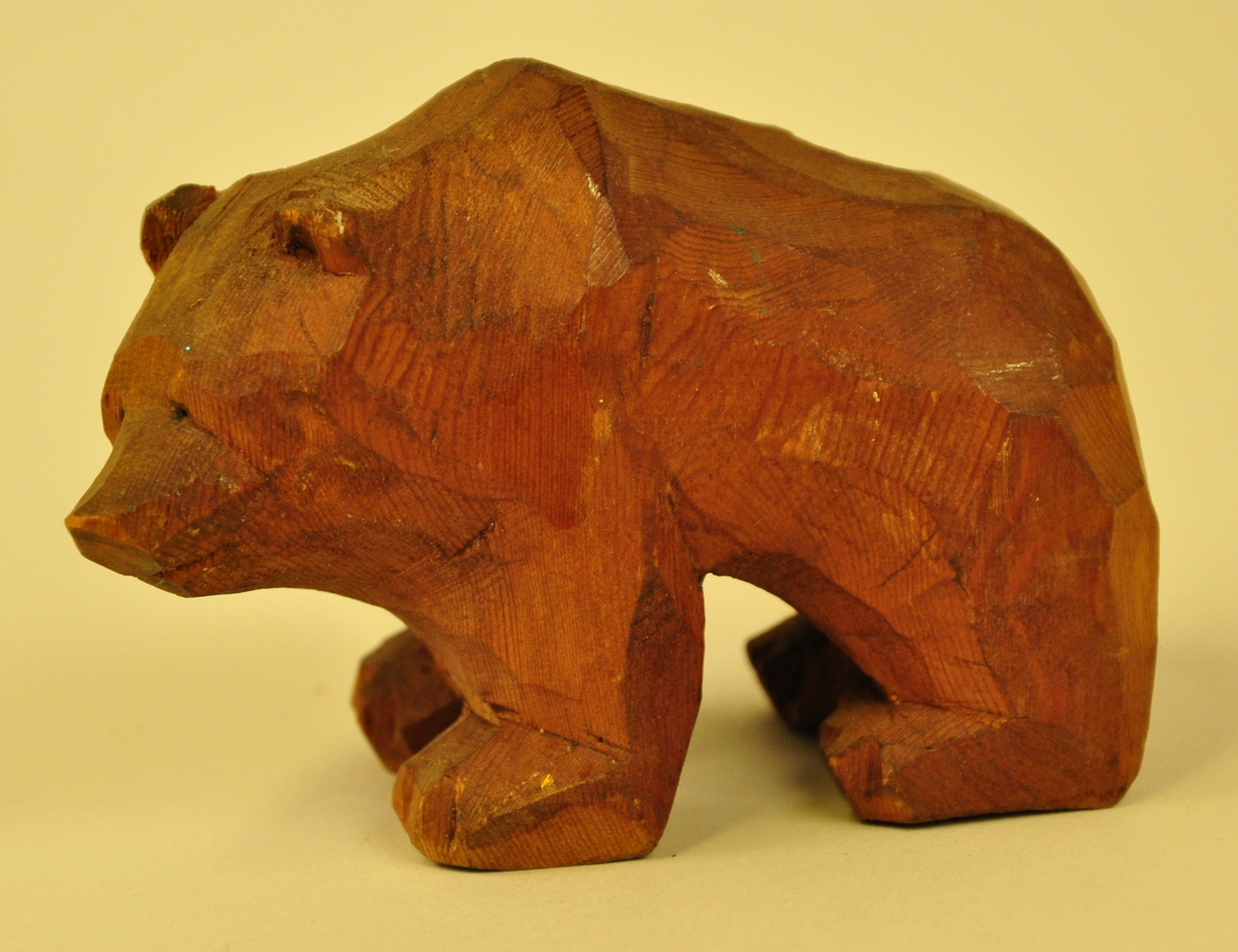 Liten, ståande bjørnefigur skoren i tre