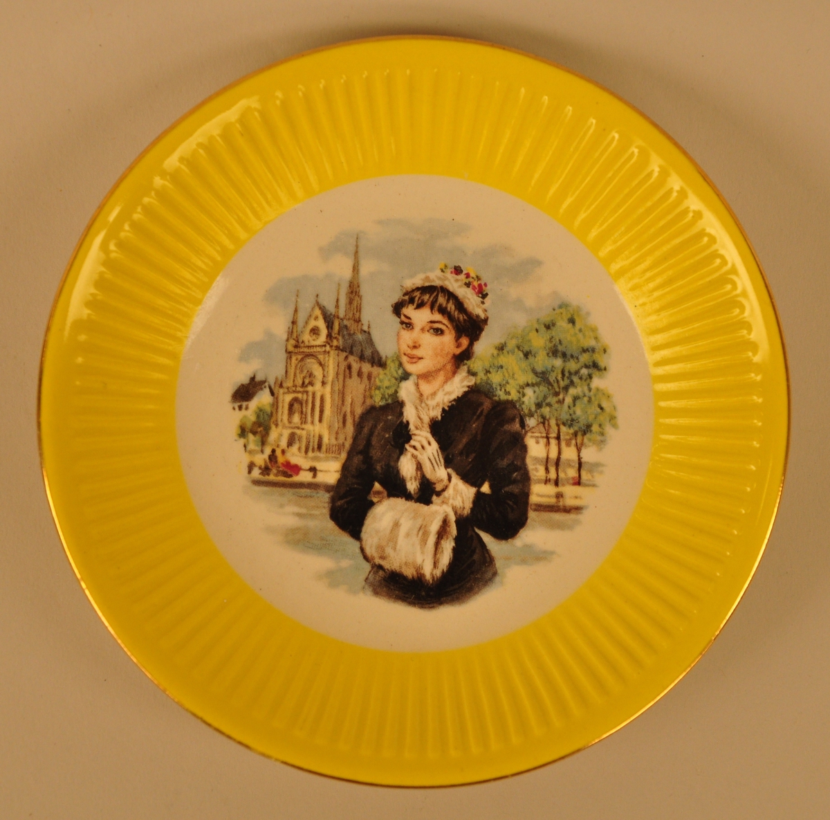 Motivet viser ei ung dame med pelshatt, sjal, hanskar og  muff. I bakgrunnen ser ein ei elv, tre og ei kyrkje i  romansk stil.