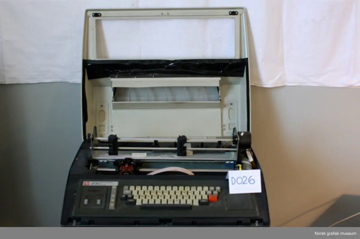 Texas Instruments TI-820 KSR Terminal. Matriseskriver med "traktor-fremtrekk" av papiret. Del av Texas Instruments' Omni 800 "printer-familie". Skriveren har tydeligvis vært en fast del av Norsk Datas datakomponenter, da den har fått NDs nummer 230 (og 151-341) i tillegg til produsentens serienummer.